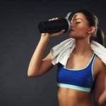 Девушка пьет протеиновый коктейль